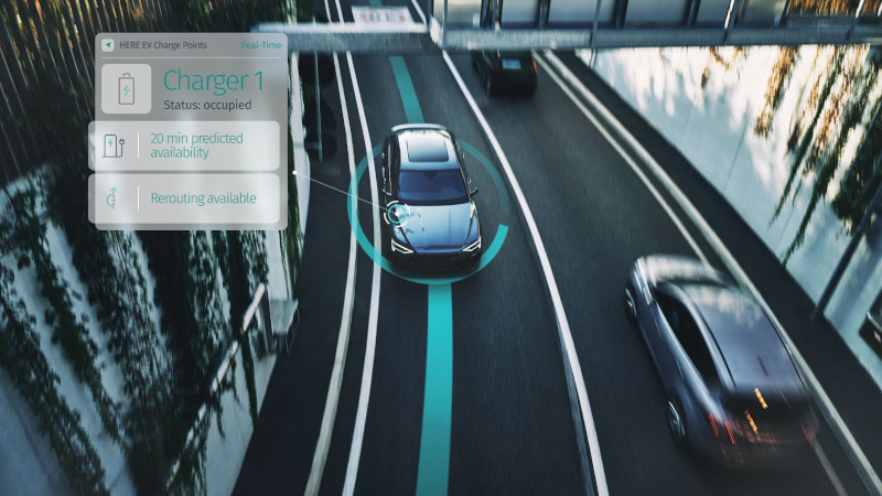 Vehicles on a street and a display showing next available charging station