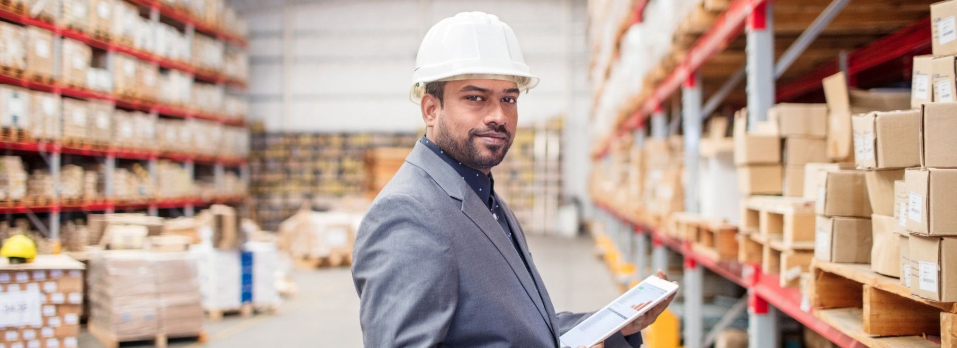 Warehouse manager looking on a tablet with real-time stock data